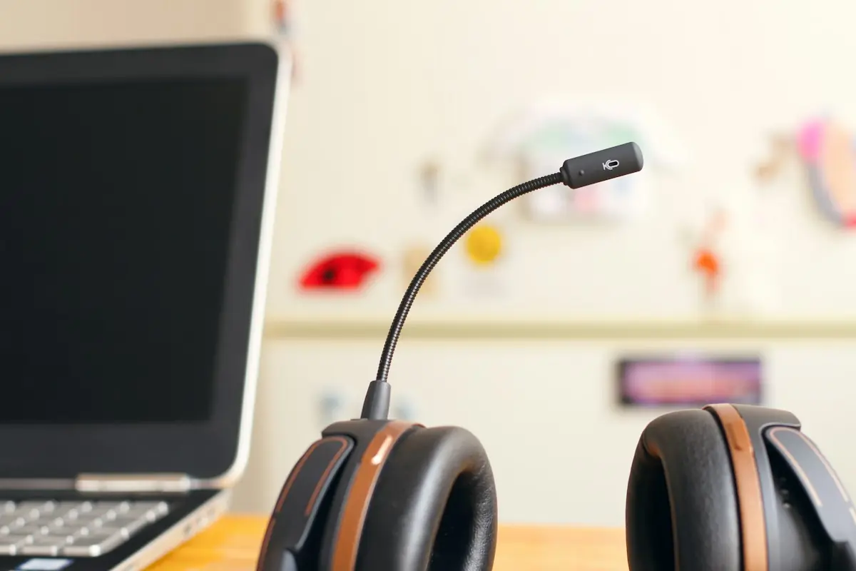 Headset resting on a desk beside a laptop